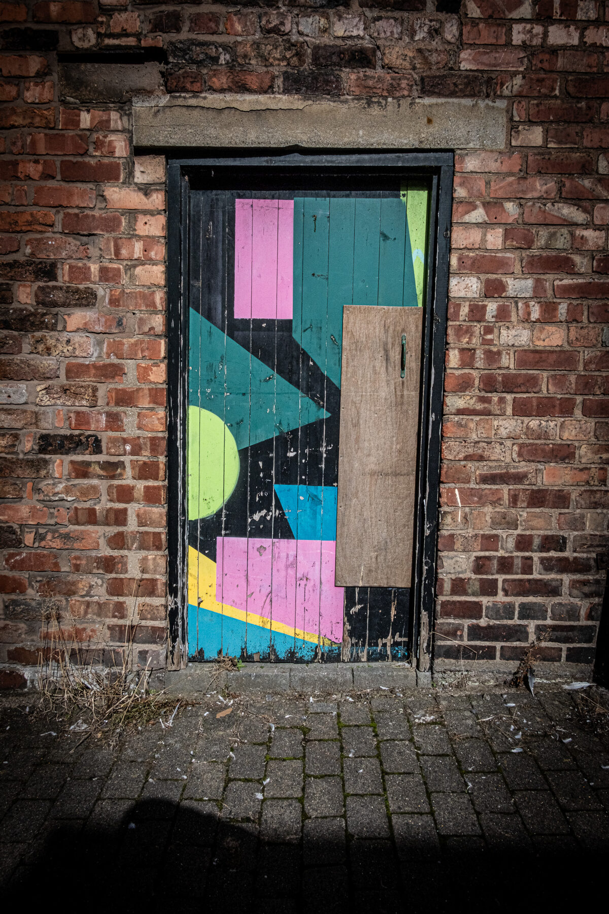 Boarded door painted with bright geometric shapes