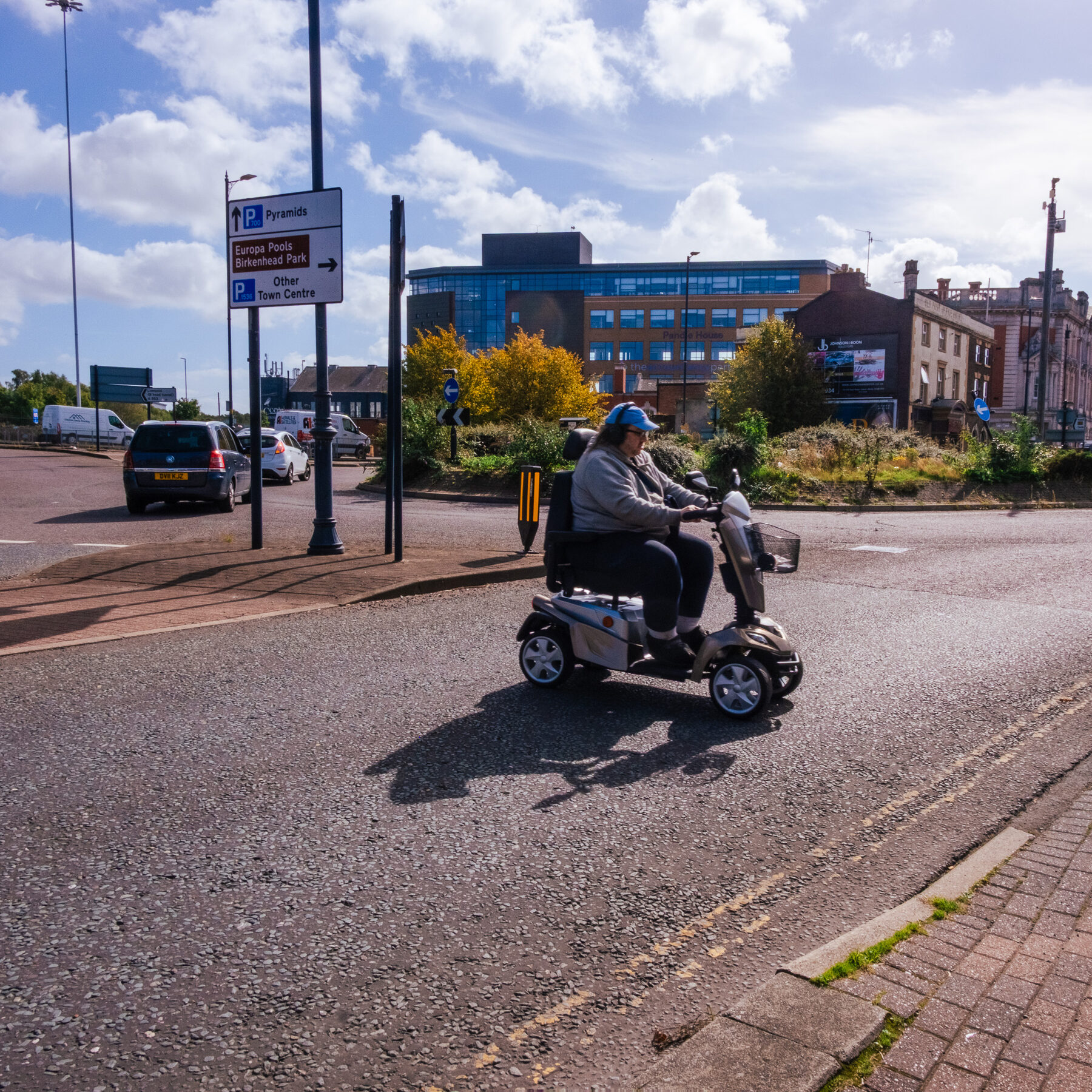 Man on a mobility scooter crossing open ground