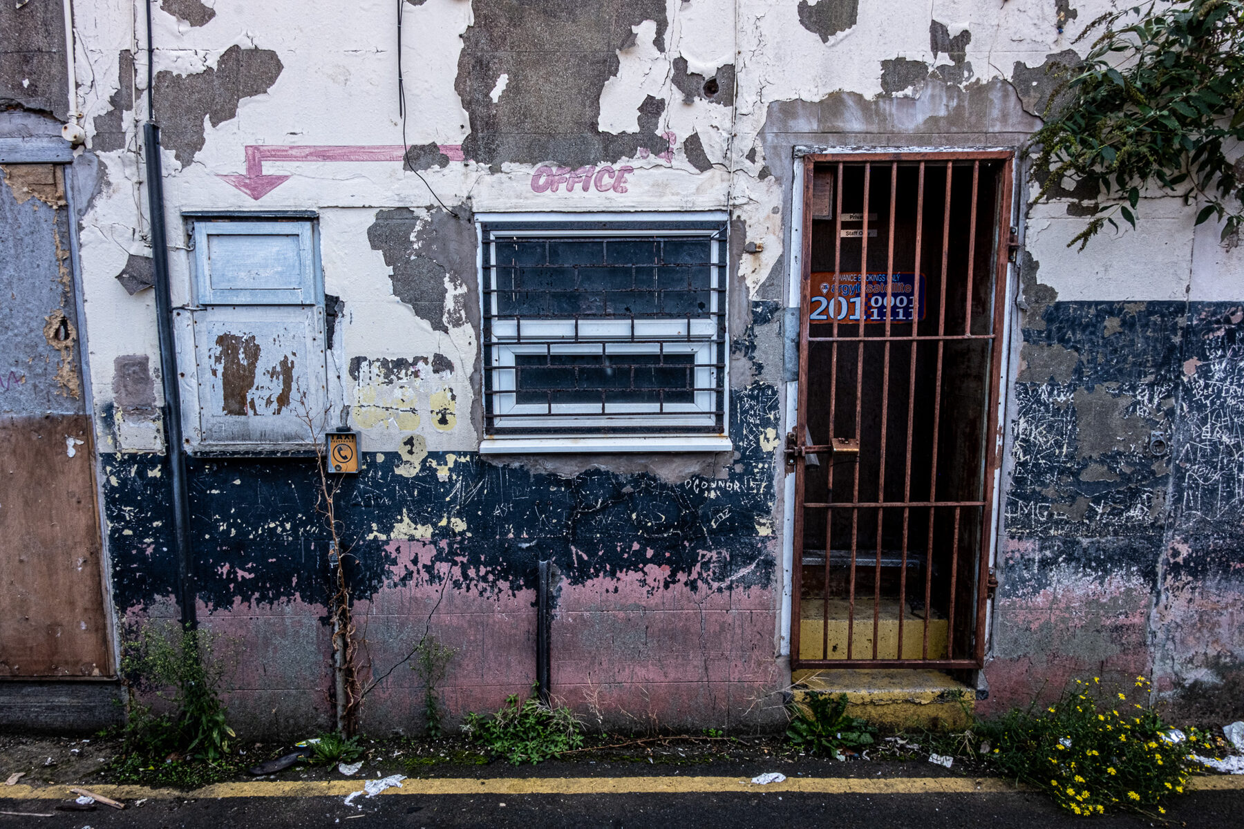 Peeling office frontage with barred window and door