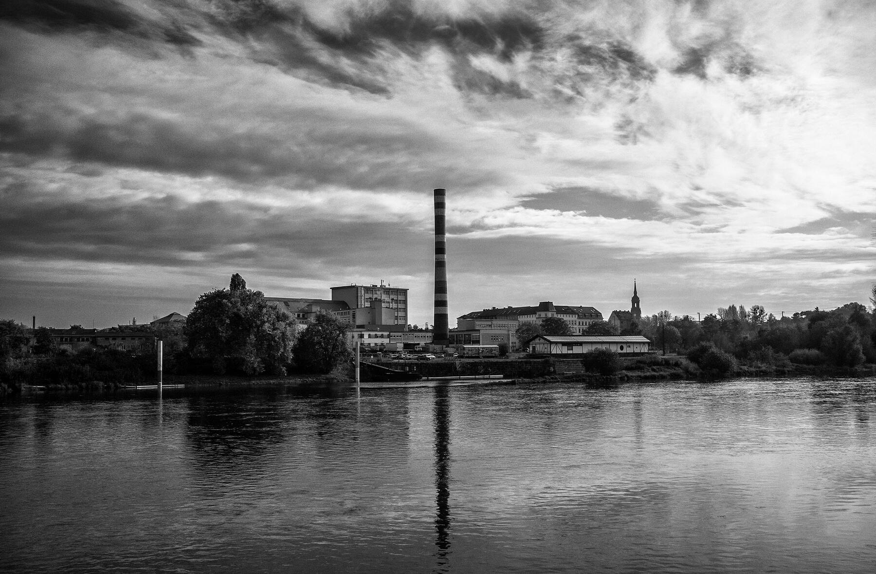 Old power station chimney across the river, black and white