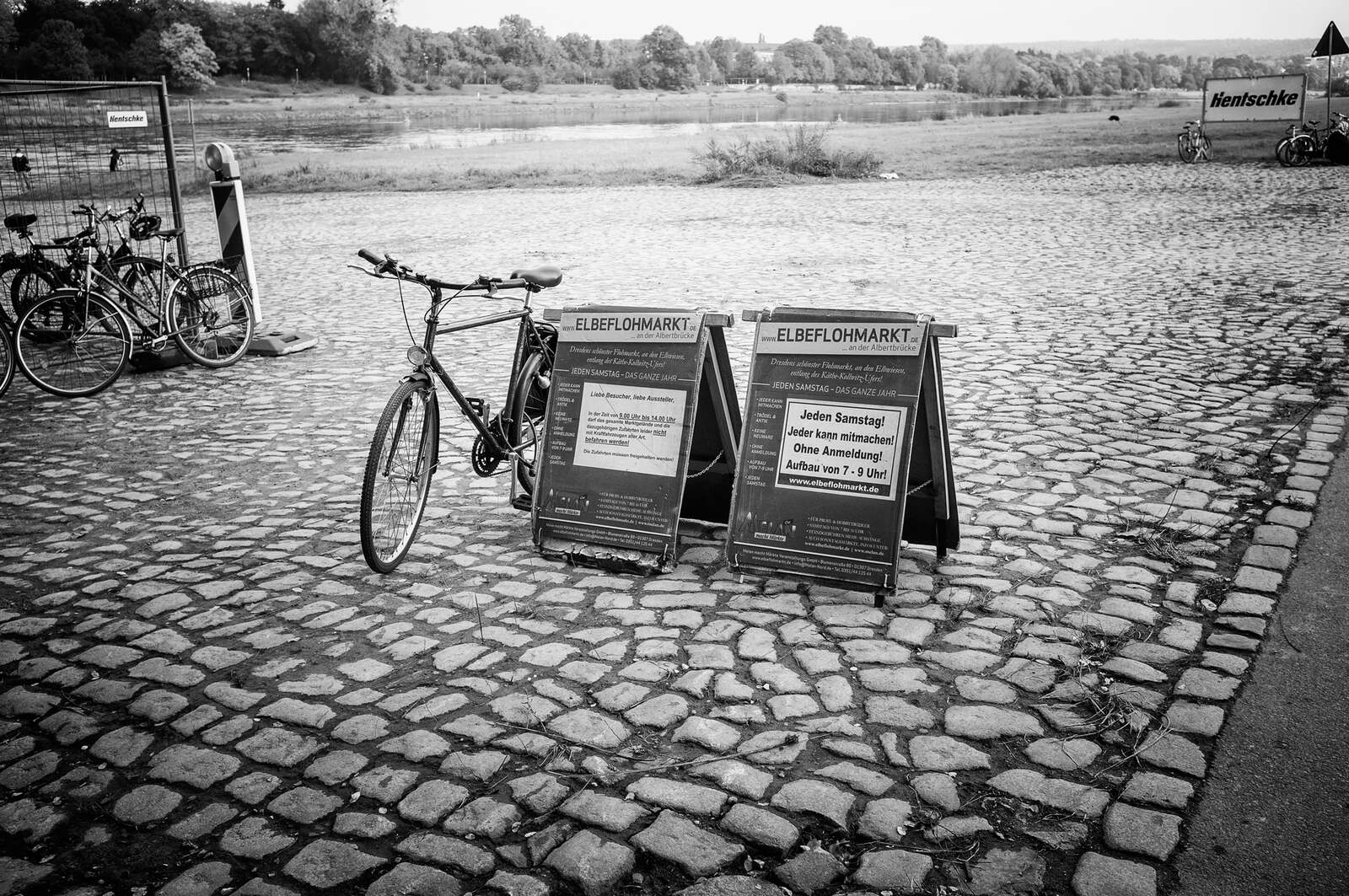 Elbeflohmarkt sandwich boards and a parked bicycle on cobbles