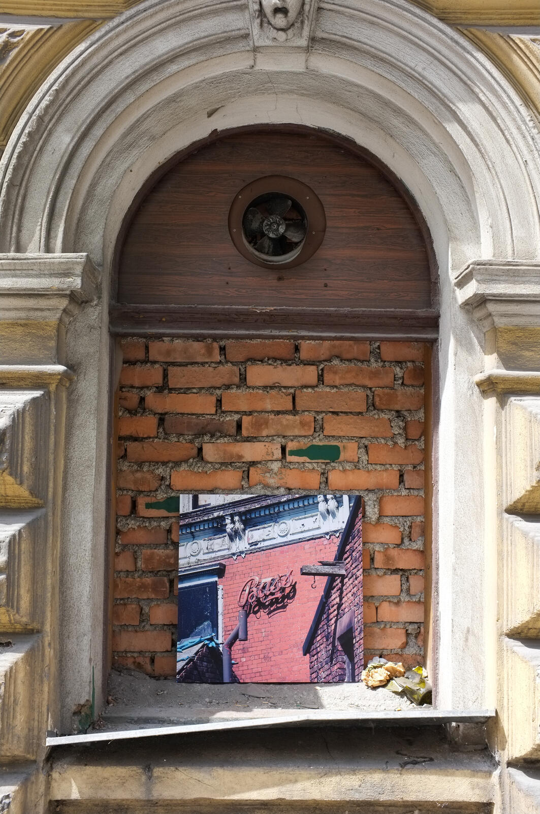 Print installed in a bricked-up arched doorway