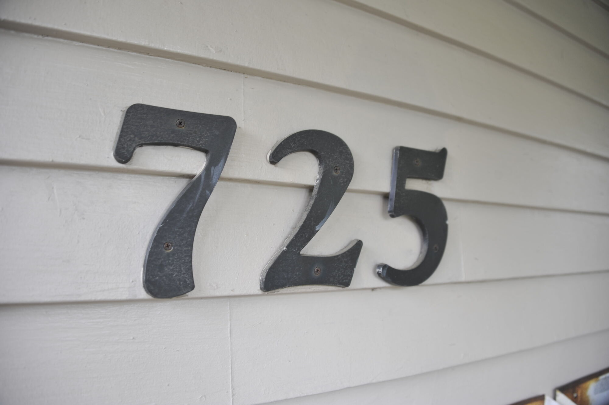 Cast house numbers 725 on clapboard siding